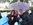 Two women and a man under an umbrella